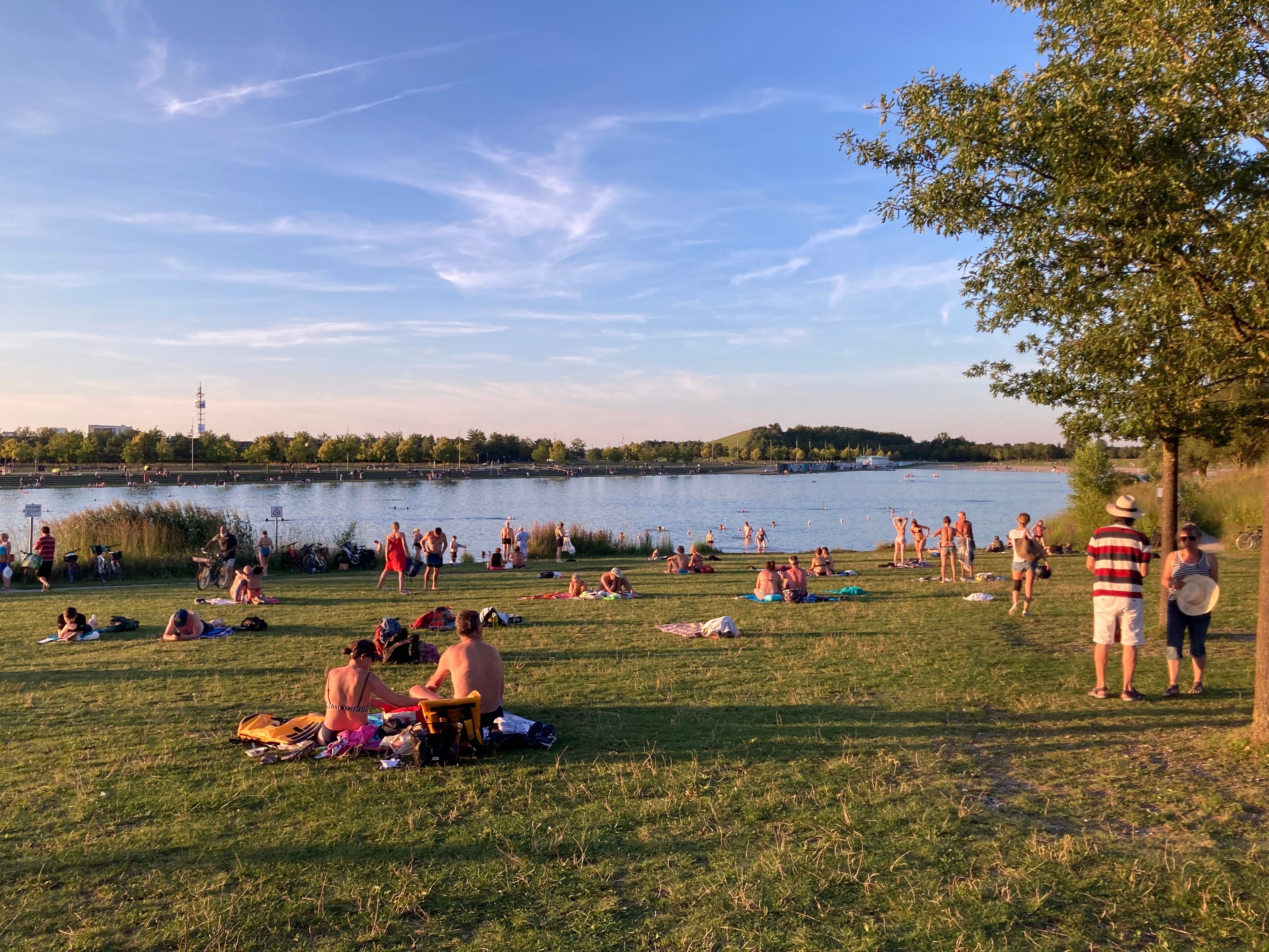 Photograph of bathers on a lake at sunset