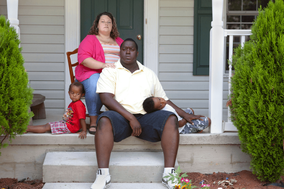 Photograph of a family of four sitting on their porch